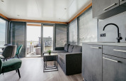 Modernes Wohnzimmer auf Hausboot „Havenlodge“ in der Marina Uitgeest, Niederlande, mit Wasserblick.