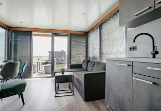 Salón moderno en la casa flotante 'Havenlodge' en Marina Uitgeest, Países Bajos, con vistas al agua.