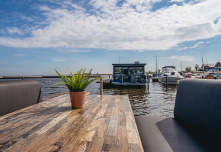View from a table on houseboat Havenlodge at Marina Uitgeest, Netherlands, showing boats and sky.