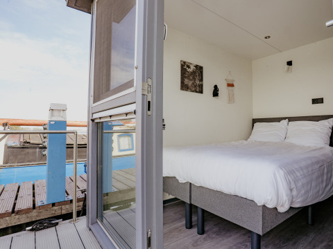 Blick in ein Schlafzimmer auf dem Hausboot Havenlodge in Marina Uitgeest, Niederlande, mit modernem Design.