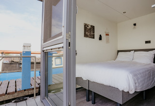 Blick in ein Schlafzimmer auf dem Hausboot Havenlodge in Marina Uitgeest, Niederlande, mit modernem Design.