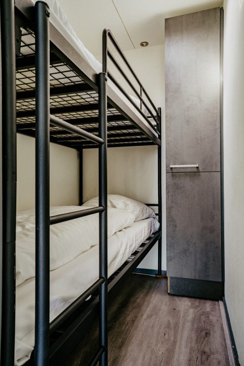 Literas modernas y armario en el camarote compacto de la Houseboat «Havenlodge» en Marina Uitgeest, Países Bajos.