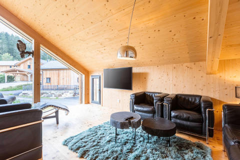 Lichte woonkamer in Kreischberg Chalets 28, Oostenrijk, met houten interieur, leren stoelen en grote ramen.