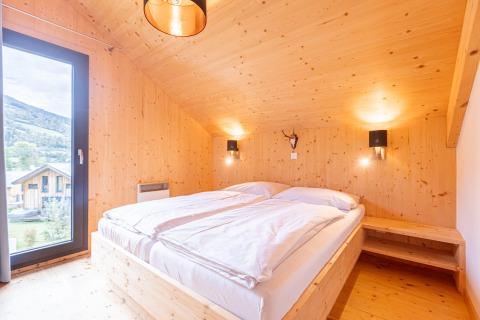 Slaapkamer in Kreischberg Chalets 28 in Oostenrijk, houten interieur, tweepersoonsbed, mooi uitzicht.