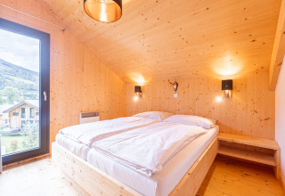 Slaapkamer in Kreischberg Chalets 28 in Oostenrijk, houten interieur, tweepersoonsbed, mooi uitzicht.