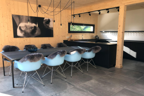 Moderne eetkamer en keuken in Kreischberg Chalets 28 in Oostenrijk met blauwe stoelen en houten muren.