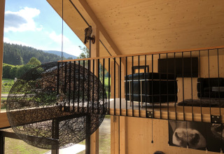 Interieur van Kreischberg Chalets 28 in Oostenrijk met moderne lounge, grote ramen en uitzicht op natuur.