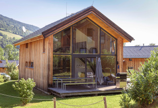 Modern houten chalet Kreischberg Chalets 28 in Oostenrijk met glazen gevel en uitzicht op de bergen.