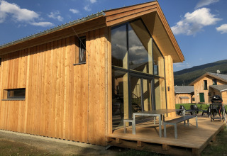 Modern houten chalet bij Kreischberg Chalets 28 in Oostenrijk met grote ramen en zonnig terras.