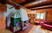 Hyggelig stue i Schneiderhütte-chalet, Østrig, med grøn kakkelovn, træpaneler og klassisk indretning.