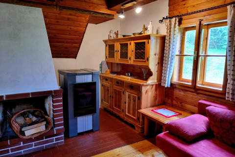 Gemütliches Zimmer in der Schneiderhütte in Österreich, mit Holzofen, Kamin und rustikalen Möbeln.