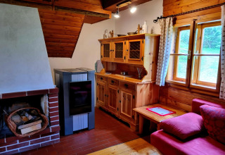 Gemütliches Zimmer in der Schneiderhütte in Österreich, mit Holzofen, Kamin und rustikalen Möbeln.