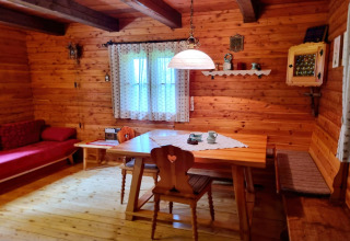 Gemütliche, holzvertäfelte Stube in der Schneiderhütte, Österreich, mit rustikaler Einrichtung.