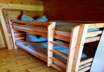 Træ køjeseng med grønt betræk og puder i Schneiderhütte chalet, Østrig, hyggelig indretning.