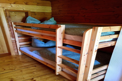 Hölzerne Etagenbetten mit grüner Bettwäsche im Chalet Schneiderhütte, Österreich, gemütlich.