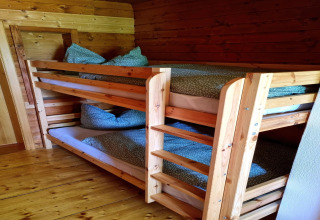 Hölzerne Etagenbetten mit grüner Bettwäsche im Chalet Schneiderhütte, Österreich, gemütlich.