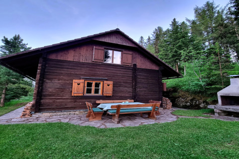 Das Schneiderhütte Chalet in Österreich mit Sitzbereich im Freien, umgeben von Bäumen und Wald.