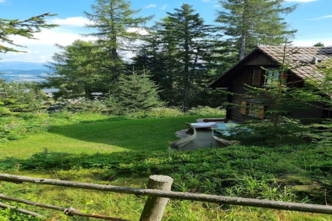 Blick auf das Chalet Schneiderhütte in Österreich, umgeben von Bäumen und herrlicher Berglandschaft.