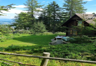 Blick auf das Chalet Schneiderhütte in Österreich, umgeben von Bäumen und herrlicher Berglandschaft.