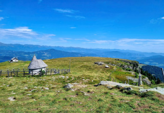 Berglandschaft bei der Schneiderhütte in Österreich mit grünen Wiesen, Hütten und weitem Alpenblick.