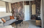 Moderne zithoek in Zonneweelde Lodge Deluxe bij Camping Zonneweelde, Nederland, met stijlvolle inrichting.
