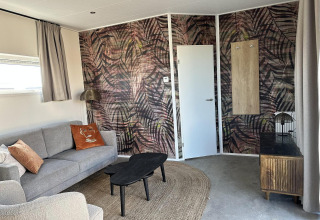 Stijlvolle zithoek in de Zonneweelde Lodge Deluxe bij Camping Zonneweelde, Nederland, modern ingericht.