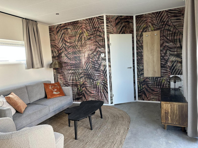 Sala de estar moderna en Zonneweelde Lodge Deluxe en Camping Zonneweelde, Países Bajos, con decoración elegante.