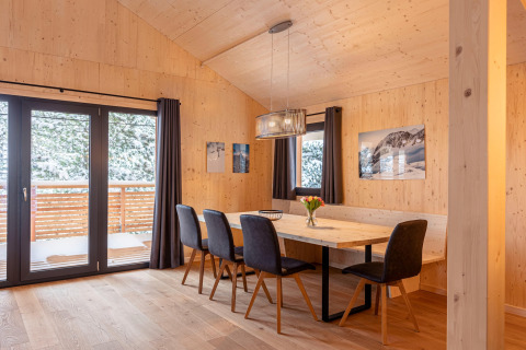 Eetruimte met houten wanden in Nature chalets Turracher Höhe 1-boomhut met sneeuwzicht in Oostenrijk.