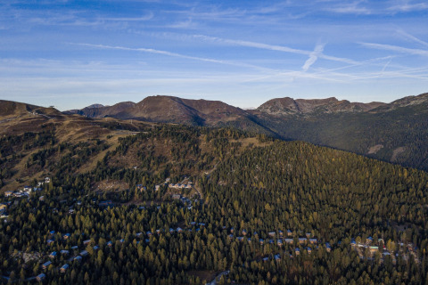 Uitzicht op bergen en bos vanaf Nature chalets Turracher Höhe 1 boomhut in Oostenrijk, onder heldere lucht.