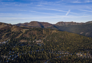 Uitzicht op bergen en bos vanaf Nature chalets Turracher Höhe 1 boomhut in Oostenrijk, onder heldere lucht.