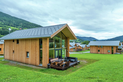Moderne Kreischberg Chalets 21 aus Holz mit großen Fenstern und Terrasse in grüner alpiner Landschaft.