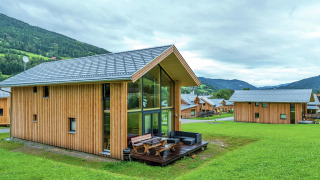 Moderne houten Kreischberg Chalets 21 met groot terras en uitzicht op groene heuvels en bergen.