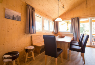 Cozy wooden dining area with leather chairs and benches at Alpenpark Turrach 21 chalet in Austria.