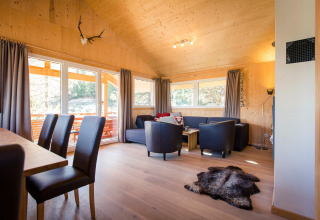 Cozy living room at Alpenpark Turrach 21, Austria, with wood interiors, large windows, and modern decor.
