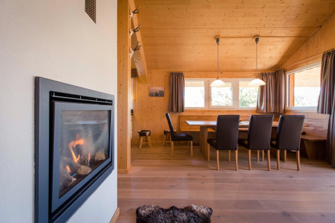 Interior view of Alpenpark Turrach 21 chalet in Austria, showing dining area with fireplace.