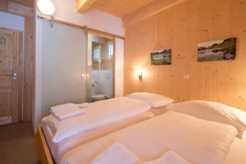 Cozy bedroom at Alpenpark Turrach 21, Austria, featuring wood-paneled walls, double bed and bathroom.