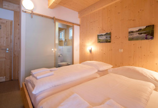 Cozy bedroom at Alpenpark Turrach 21, Austria, featuring wood-paneled walls, double bed and bathroom.
