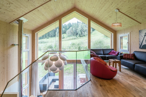 Modernes Wohnzimmer im Kreischberg Chalets 21, Österreich, mit großen Fenstern und Blick auf die Natur.