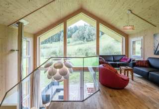 Modernes Wohnzimmer im Kreischberg Chalets 21, Österreich, mit großen Fenstern und Blick auf die Natur.