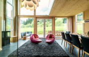 Salon moderne au Kreischberg Chalets 21 en Autriche, grandes baies vitrées, vue sur la nature et mobilier design.