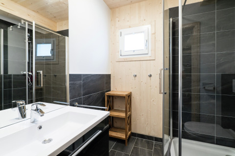 Modernes Badezimmer im Kreischberg Chalets 21 in Österreich mit Glasdusche und Holzwänden.