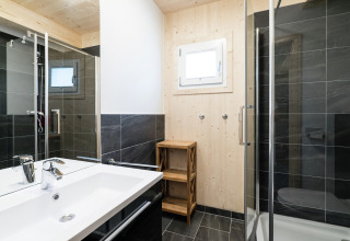 Modernes Badezimmer im Kreischberg Chalets 21 in Österreich mit Glasdusche und Holzwänden.