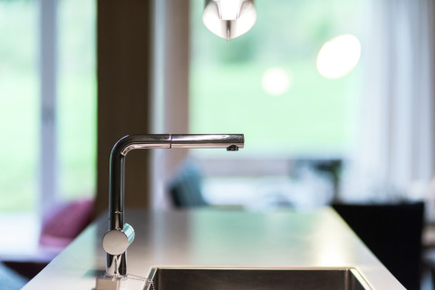 Moderner Küchenwasserhahn im Kreischberg Chalets 21 in Österreich, mit Blick auf ein wohnliches Zimmer.