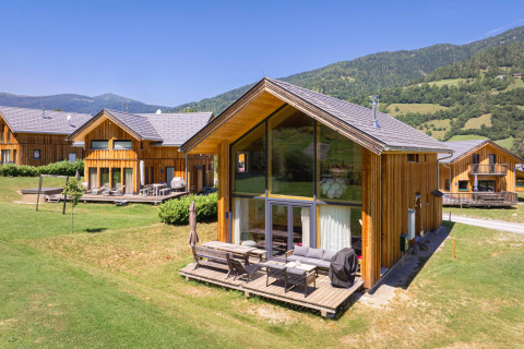 Holzchalet bei Kreischberg Chalets 21 in Österreich mit Terrasse, grüner Wiese und Bergblick im Sommer.