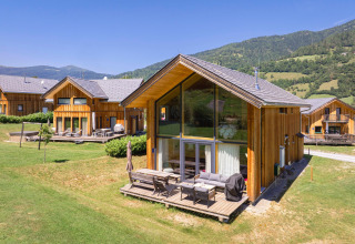 Holzchalet bei Kreischberg Chalets 21 in Österreich mit Terrasse, grüner Wiese und Bergblick im Sommer.