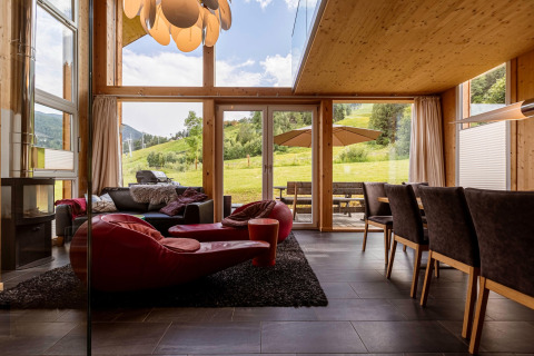 Innenansicht des Kreischberg Chalets 21 mit modernen Möbeln und Panoramablick auf die Alpenwiese.
