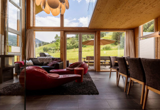 Innenansicht des Kreischberg Chalets 21 mit modernen Möbeln und Panoramablick auf die Alpenwiese.