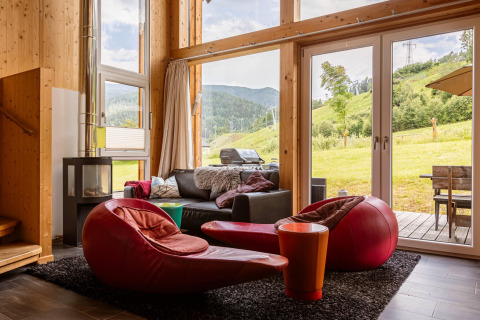 Wohnbereich in Kreischberg Chalets 21, Österreich, mit moderner Einrichtung und Blick auf die Alpenhänge.