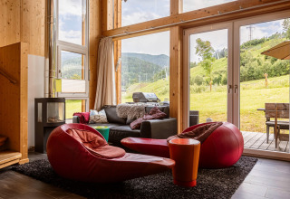 Wohnbereich in Kreischberg Chalets 21, Österreich, mit moderner Einrichtung und Blick auf die Alpenhänge.