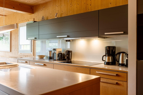 Moderne Küche im Chalet „Kreischberg Chalets 21“ in Österreich mit Holzverkleidung und Küchengeräten.